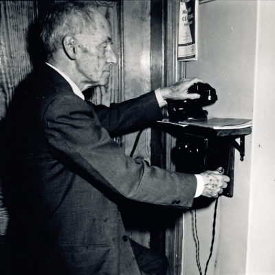 Castine Resident Willis Ricker using the crank phone, 1956. Photo by Ed Langolis.