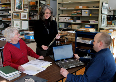 Curator Paige Lilly with volunteers Fran Bos and Mike Marshall